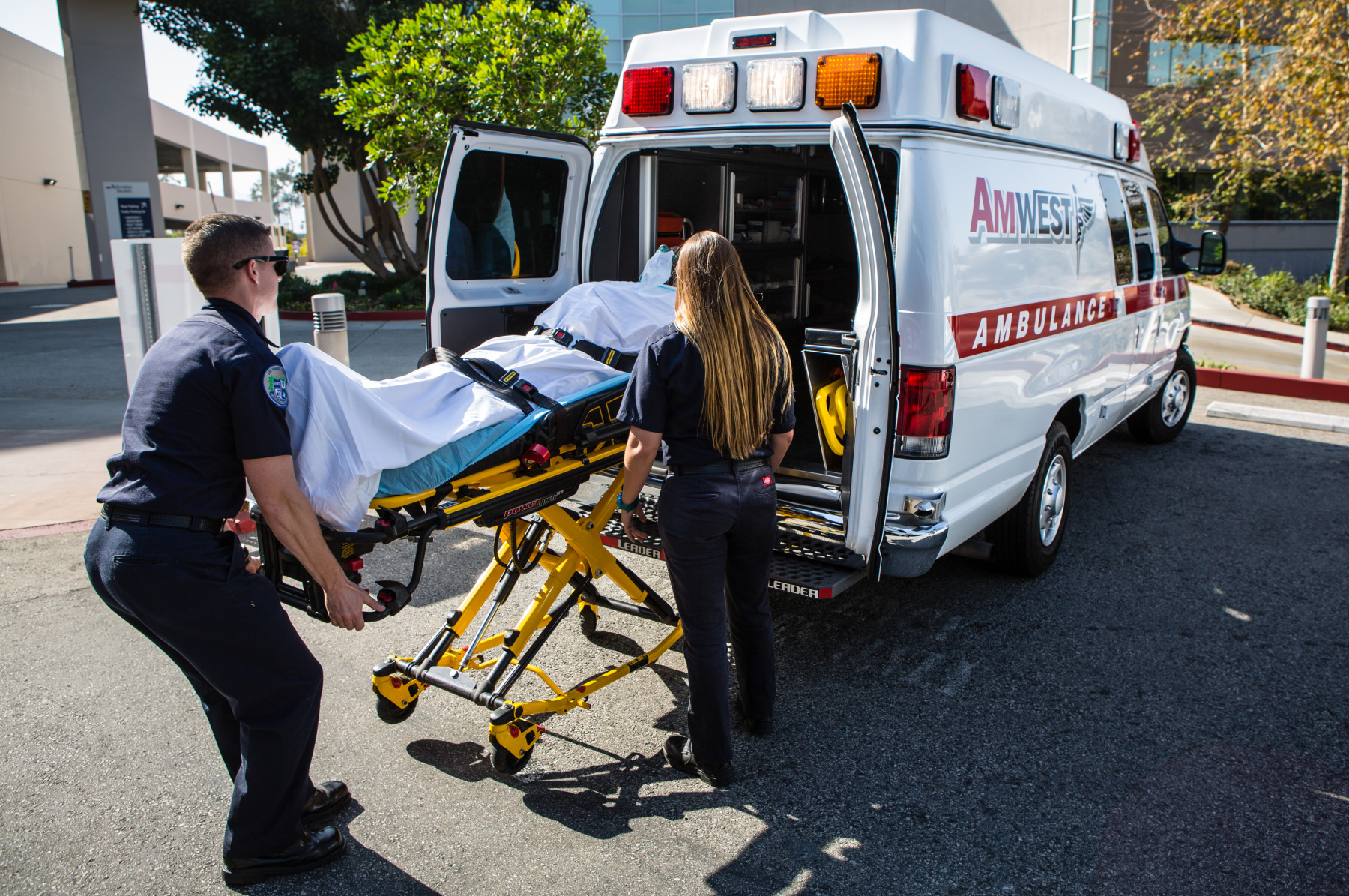 AmWest Ambulance vehicle with paramedic staff outside a medical facility
