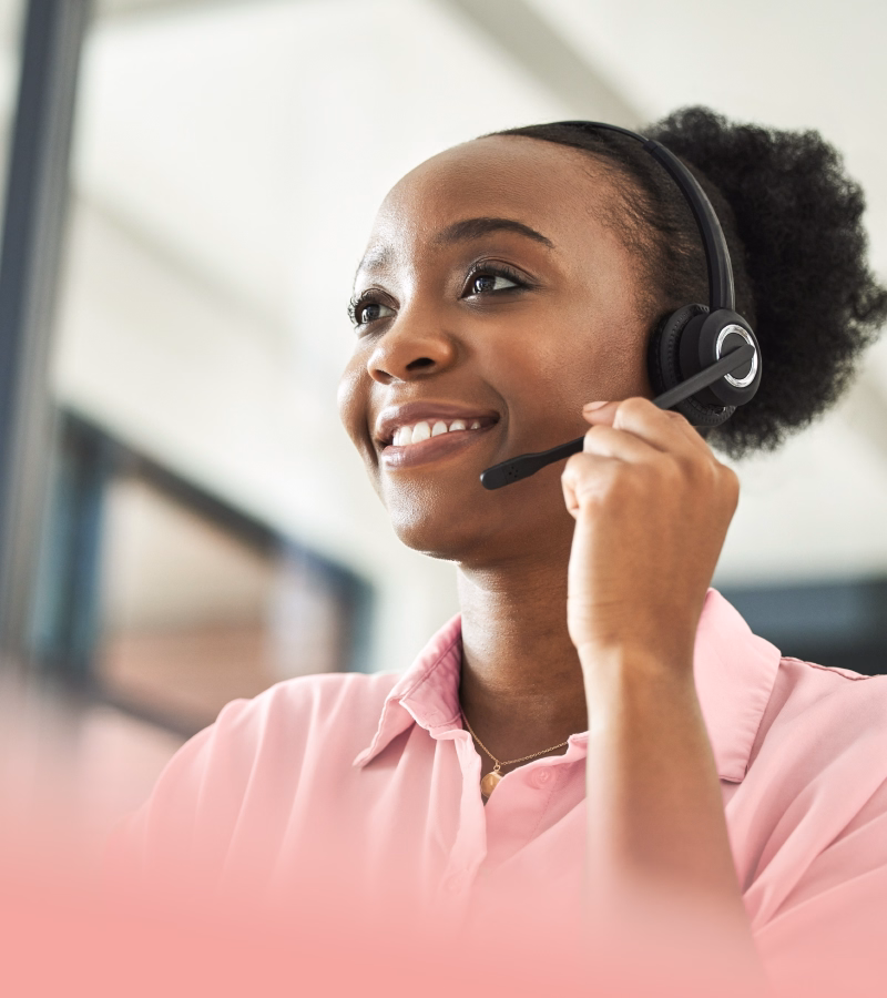 Customer support representative on headset smiling in a bright office