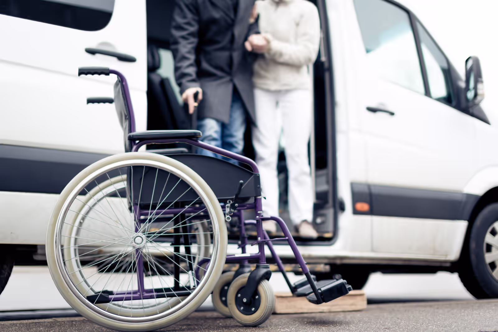 Elderly PACE participant being assisted into a medical transport vehicle